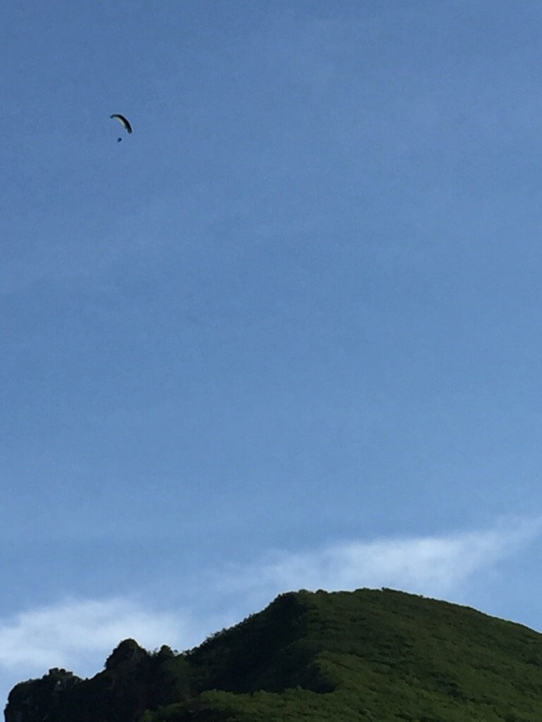 山の上にパラグライダーが飛んでいる