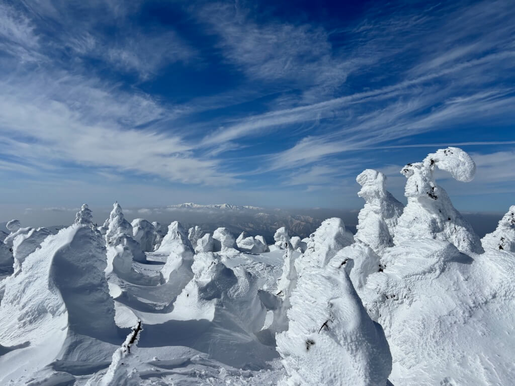 山頂から見える雪山。磐梯山かな?